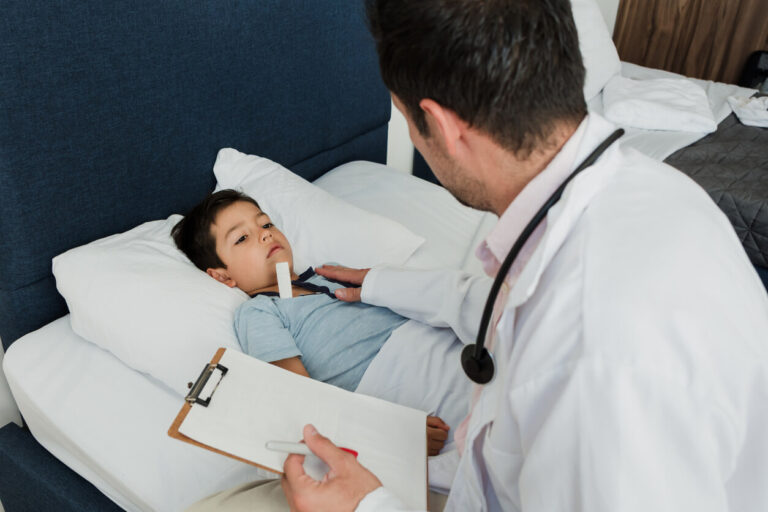 Pediatrician doctor consulting or checking on a child in bed.