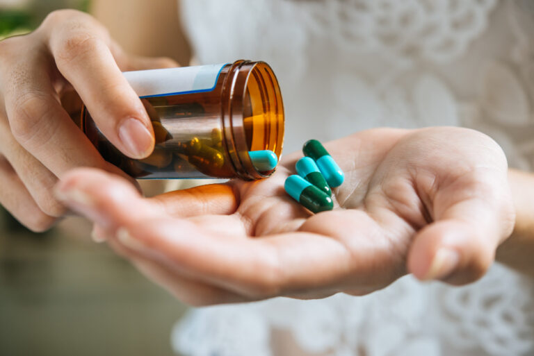 close up of a hand taking medicine, urgenct care can prescribe antibiotics
