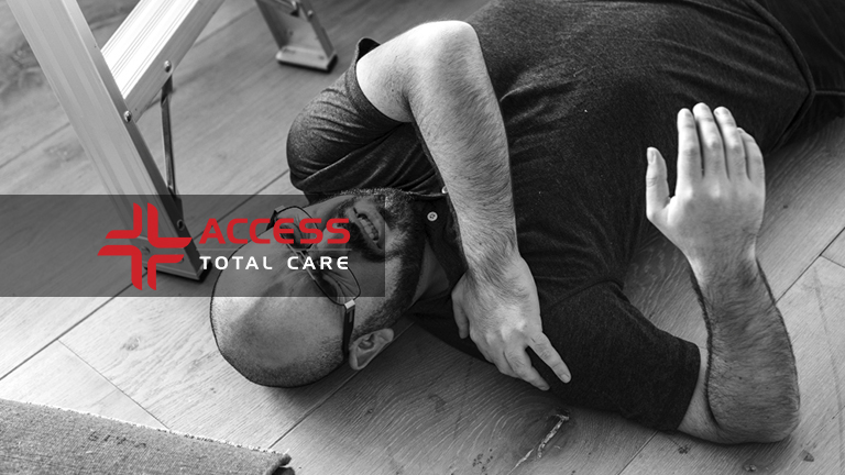 a bald middle aged man with glasses lying on the ground in pain from a slip and fall accident