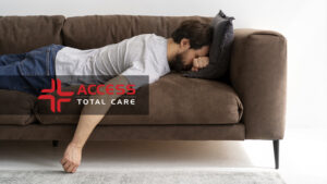 an exhausted man lying face down on a couch sufering from winter fatigue