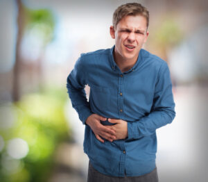 Man clutching his stomach, showing digestive discomfort.